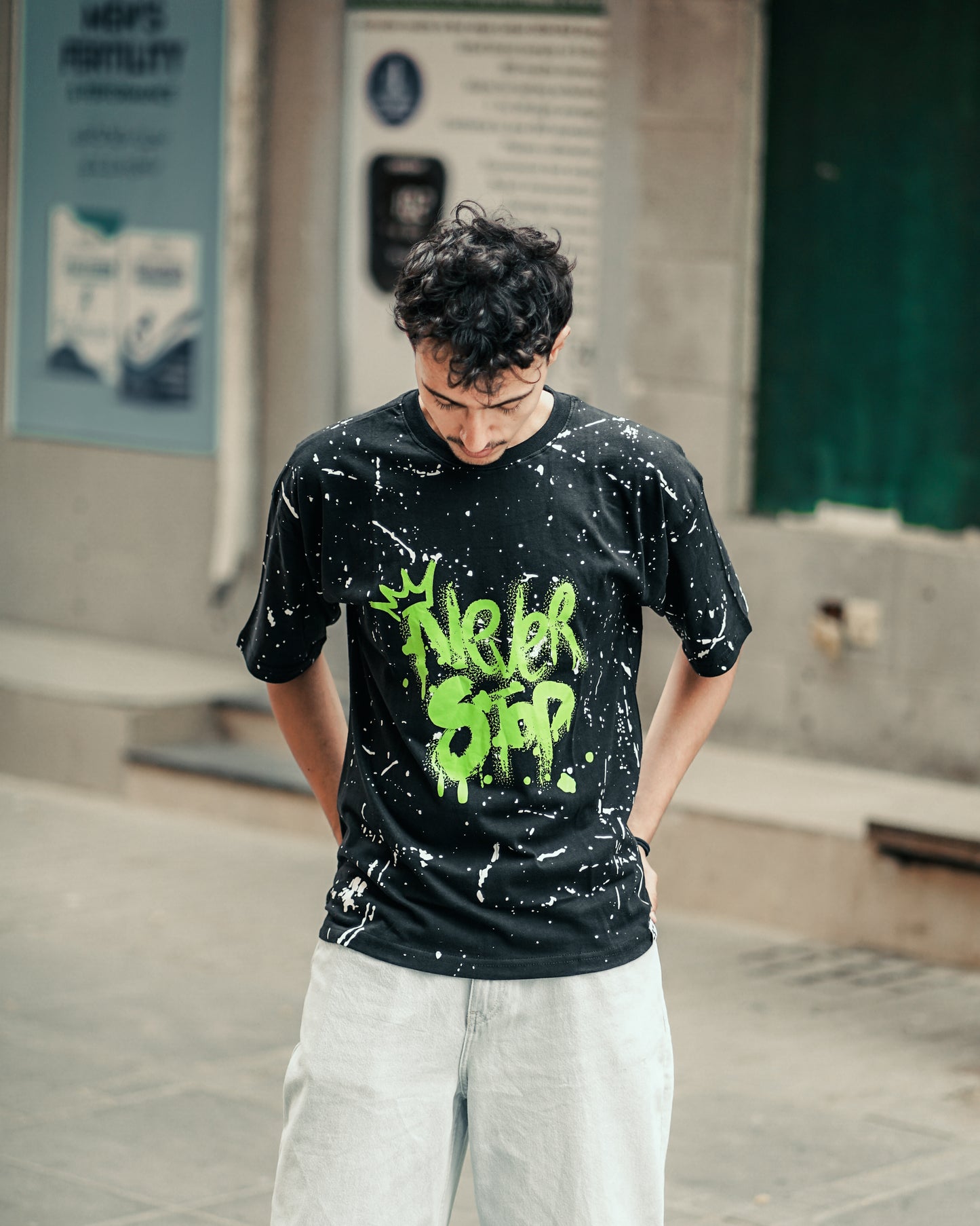 "NEVER STOP" Oversized Streetwear T-Shirt – All-Over Splatter Print (Black)