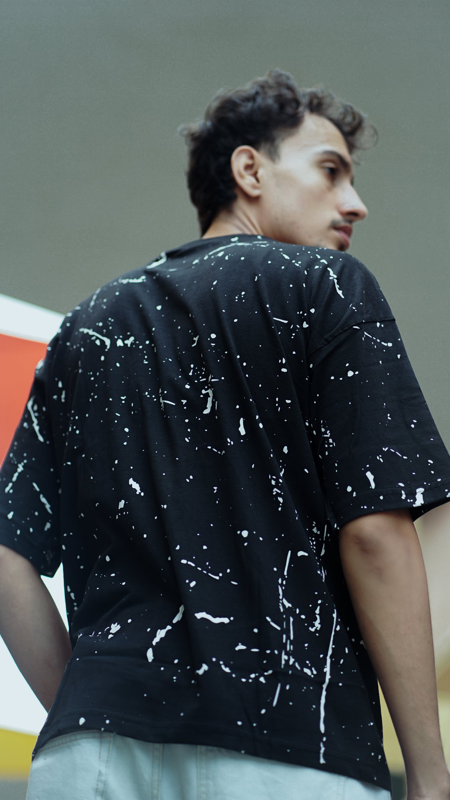 "NEVER STOP" Oversized Streetwear T-Shirt – All-Over Splatter Print (Black)
